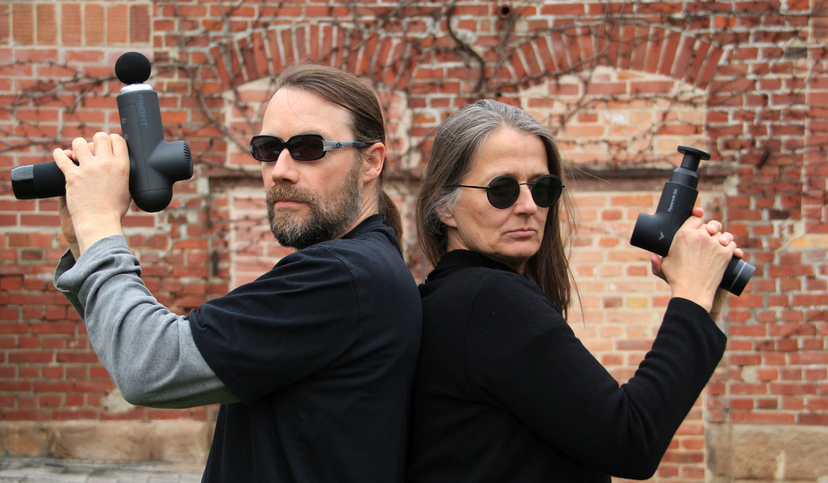 James Bond like Stefan und Annette posieren mit der Massagepistole
